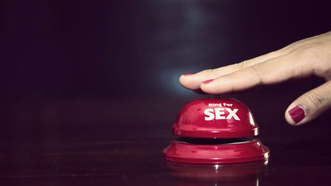 woman's hands press sex bell on a reception bell. concept about sex and eroticism